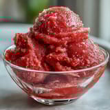 Creamy strawberry sorbet infused with zesty lime and white rum, served in chilled glasses with a garnish of fresh mint.