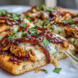 Grilled BBQ chicken flatbread pizza topped with fresh cilantro and jalapeños, offering a burst of flavor in every bite.  