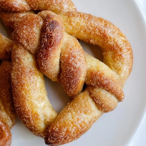 Close-up of fluffy Cinnamon Sugar Pretzels, coated in a generous layer of warmly spiced cinnamon sugar.