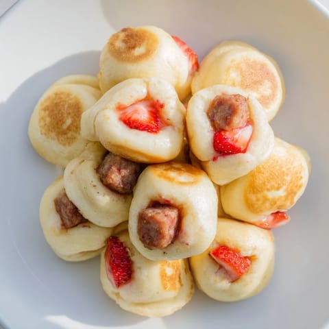 Warm and fluffy pancake bites, bursting with fresh fruit, are a delightful breakfast treat, visually appealing.