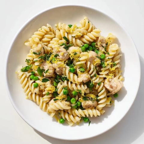 This Garlic Butter Chicken & Pea Pasta features tender chicken and al dente pasta coated in a lemony Parmesan sauce.