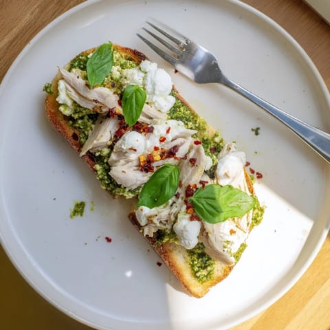 Freshly toasted sourdough slices spread with homemade pesto, piled high with juicy, seasoned chicken and melty burrata cheese for a satisfying Italian-inspired lunch.