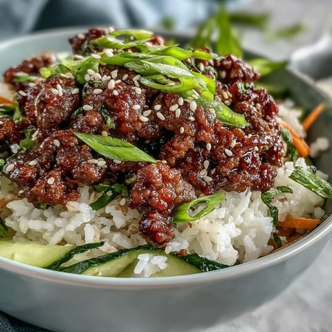 A close-up of a Korean ground beef bowl featuring fluffy cauliflower rice, savory beef, and tangy quick-pickled veggies.