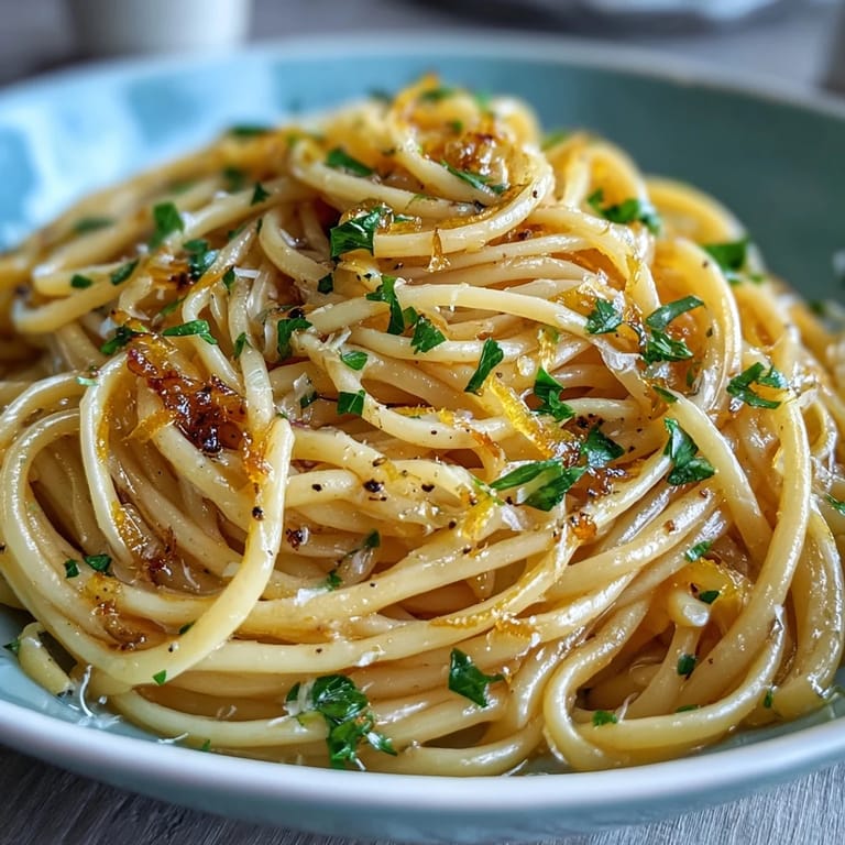 Silky spaghetti coated in rich lemon butter sauce, with vibrant zest and Parmesan cheese, perfect for a quick vegetarian dinner.