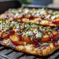 Grilled BBQ peach and Brie flatbread with smoky sauce, sweet peaches, and melted cheese.  